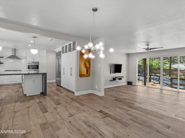 189 Ray Way, Zephyr Cove, NV 89448 - kitchen with appliances with stainless steel finishes, wall chimney exhaust hood, open floor plan, white cabinets, and backsplash