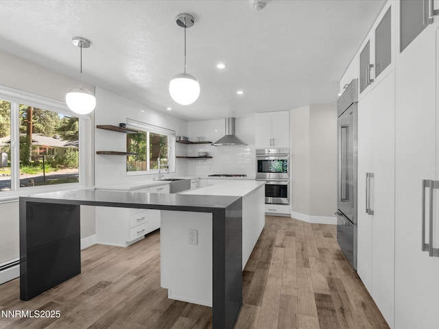 189 Ray Way, Zephyr Cove, NV 89448 - kitchen featuring double oven, wall chimney range hood, open shelves, light wood finished floors, and white cabinetry