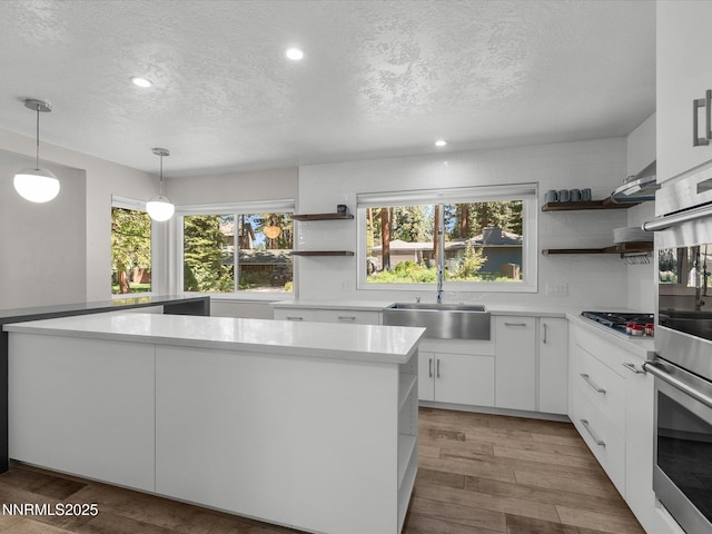 189 Ray Way, Zephyr Cove, NV 89448 - kitchen featuring open shelves, a textured ceiling, light countertops, white cabinetry, and pendant lighting