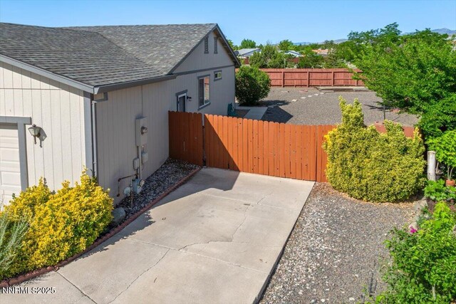 7202 Leonardo Ct, Sun Valley, NV 89433 - view of side of property with a shingled roof and a gate