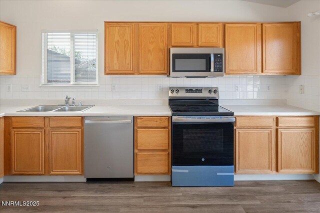 7202 Leonardo Ct, Sun Valley, NV 89433 - kitchen with stainless steel appliances, tasteful backsplash, light countertops, and dark wood-style flooring
