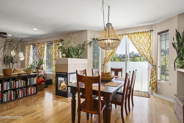3744 Ranch Crest Dr, Reno, NV 89509 - dining area with light wood-style floors, a chandelier, a tiled fireplace, and recessed lighting