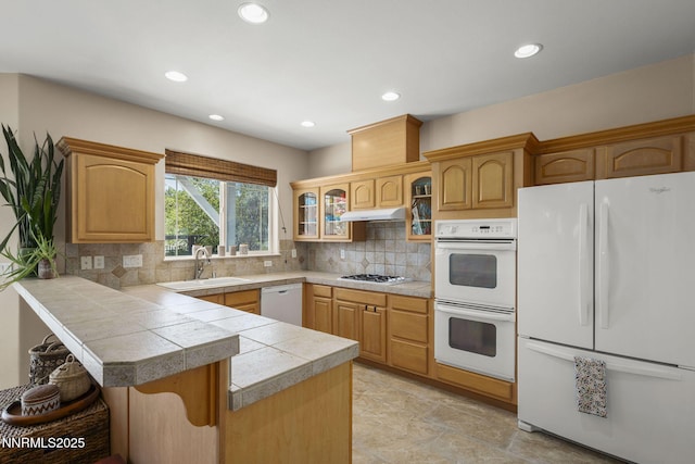 3744 Ranch Crest Dr, Reno, NV 89509 - kitchen with white appliances, a kitchen bar, under cabinet range hood, glass insert cabinets, and a peninsula