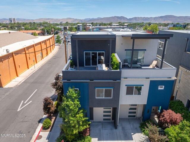 1402 Tonopah St, Reno, NV 89509 - contemporary house featuring stucco siding, a mountain view, a garage, and driveway