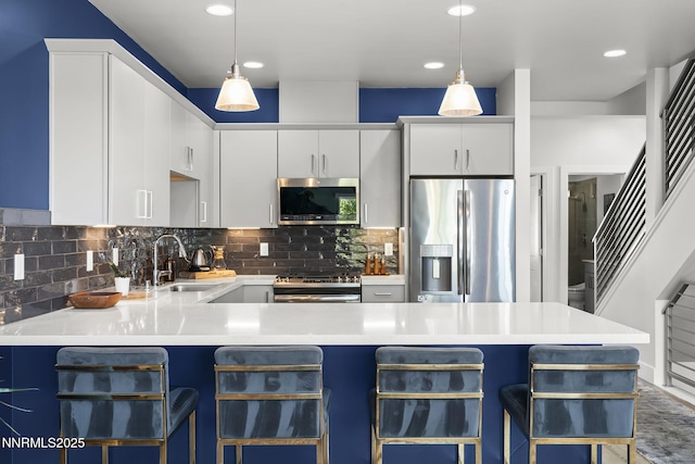 1402 Tonopah St, Reno, NV 89509 - kitchen with appliances with stainless steel finishes, a breakfast bar, backsplash, decorative light fixtures, and recessed lighting
