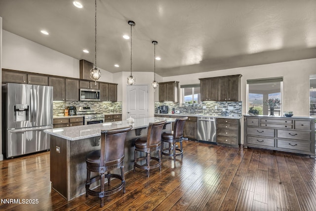 150 Brandon Ranch Ct, Reno, NV 89510 - kitchen featuring stainless steel appliances, dark brown cabinets, a center island, backsplash, and vaulted ceiling