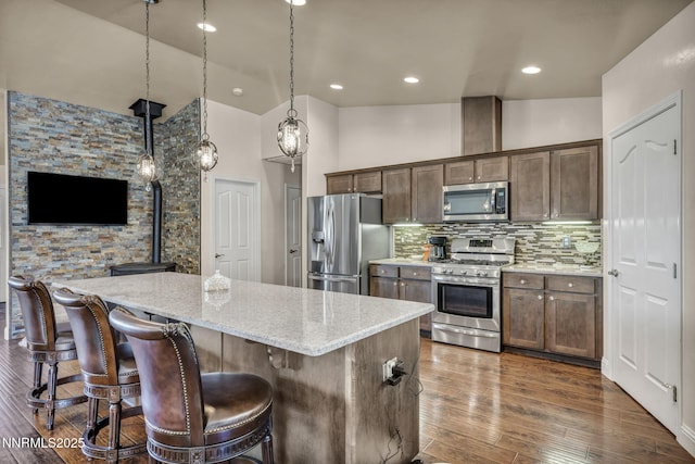 150 Brandon Ranch Ct, Reno, NV 89510 - kitchen with stainless steel appliances, a kitchen island, light stone counters, tasteful backsplash, and dark wood finished floors