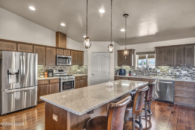 150 Brandon Ranch Ct, Reno, NV 89510 - kitchen with stainless steel appliances, dark wood-type flooring, a kitchen bar, a center island, and decorative backsplash