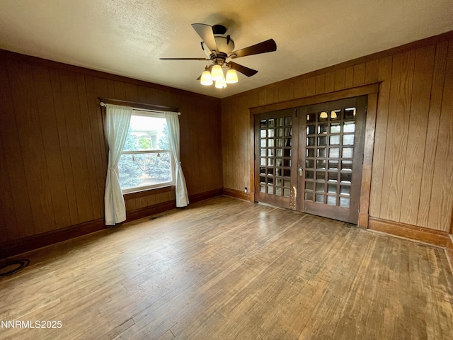 77 Lay St, Winnemucca, NV 89445 - empty room featuring wood finished floors, wooden walls, and ceiling fan