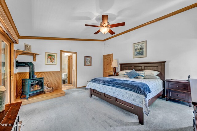 1008 Georgia Ln, Gardnerville, NV 89460 - carpeted bedroom featuring a wood stove, vaulted ceiling, crown molding, ceiling fan, and ensuite bathroom