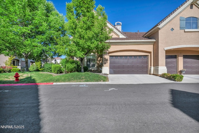 9900 Wilbur May Pkwy Unit 2001, Reno, NV 89521 - view of front of home featuring stucco siding, a front yard, a chimney, and driveway