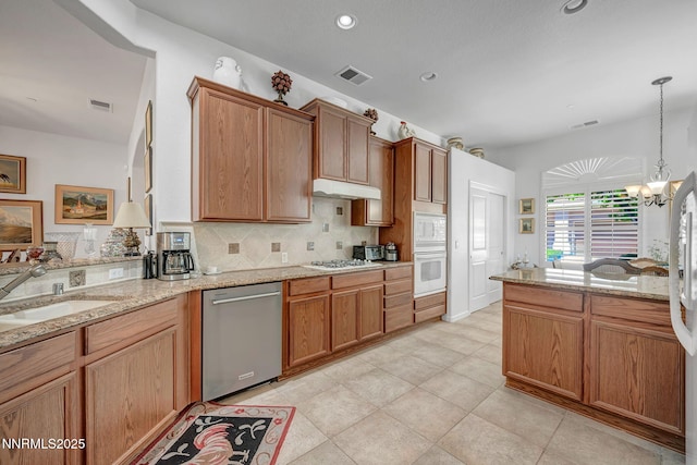 9900 Wilbur May Pkwy Unit 2001, Reno, NV 89521 - kitchen with white appliances, under cabinet range hood, backsplash, light stone countertops, and recessed lighting