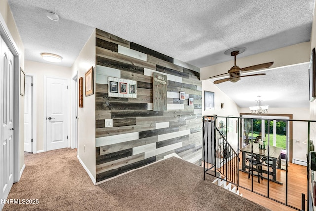 700 Highland St, Carson City, NV 89703 - corridor featuring wooden walls, a textured ceiling, an upstairs landing, a chandelier, and an accent wall