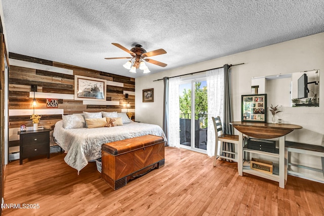 700 Highland St, Carson City, NV 89703 - bedroom with wood walls, access to exterior, hardwood / wood-style flooring, a textured ceiling, and a baseboard radiator