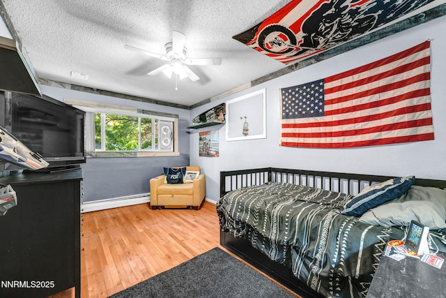 700 Highland St, Carson City, NV 89703 - bedroom with a baseboard radiator, hardwood / wood-style flooring, a textured ceiling, and ceiling fan