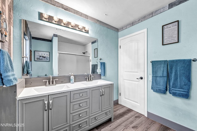 700 Highland St, Carson City, NV 89703 - full bathroom featuring double vanity, wood finished floors, a shower with door, and a textured wall