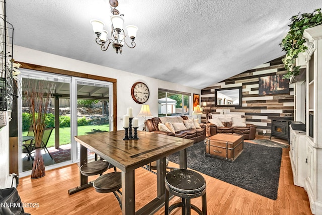700 Highland St, Carson City, NV 89703 - dining room with a textured ceiling, vaulted ceiling, wood finished floors, a chandelier, and a wood stove