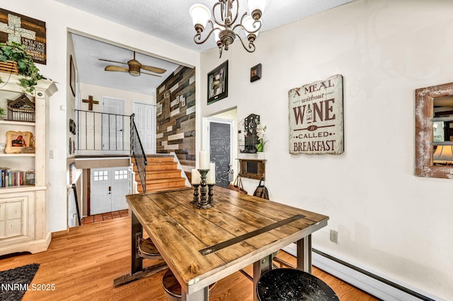 700 Highland St, Carson City, NV 89703 - dining room featuring stairs, light wood finished floors, a baseboard radiator, a chandelier, and a ceiling fan