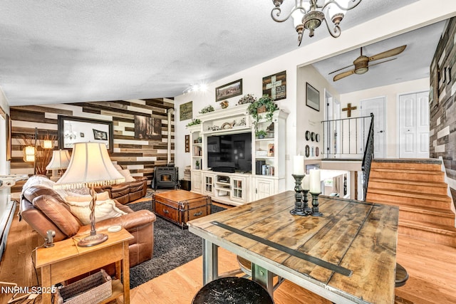 700 Highland St, Carson City, NV 89703 - living room featuring a wood stove, wood finished floors, stairs, a textured ceiling, and a chandelier
