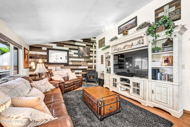 700 Highland St, Carson City, NV 89703 - living room featuring a wood stove, a textured ceiling, wood finished floors, and wood walls