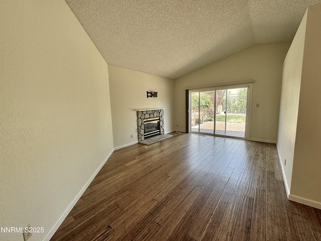 6559 Fall River Cir, Reno, NV 89523 - unfurnished living room with dark wood-style floors, vaulted ceiling, a textured ceiling, and a fireplace
