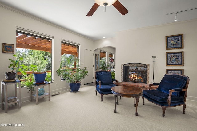 2548 Jacks Valley Rd, Genoa, NV 89411 - living area with carpet floors, a brick fireplace, ornamental molding, plenty of natural light, and a ceiling fan