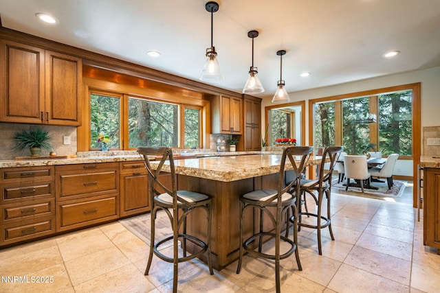5 Kelly Cir, Glenbrook, NV 89413 - kitchen with brown cabinetry, decorative backsplash, recessed lighting, light stone countertops, and a kitchen island