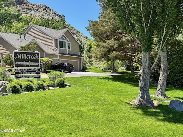 4066 Snowshoe Ln, Reno, NV 89502 - view of grassy yard featuring an attached garage, driveway, and a mountain view