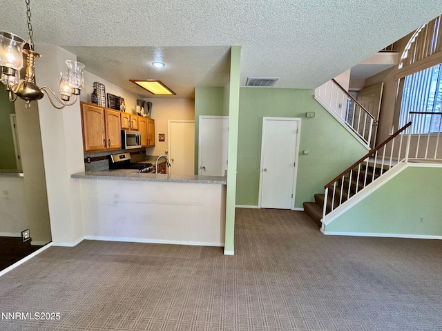 4066 Snowshoe Ln, Reno, NV 89502 - kitchen with appliances with stainless steel finishes, a chandelier, carpet floors, a textured ceiling, and light countertops