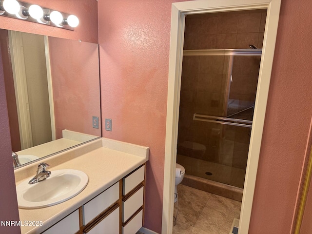 4066 Snowshoe Ln, Reno, NV 89502 - bathroom with a textured wall, a stall shower, vanity, and tile patterned floors