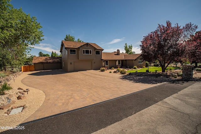 15045 Heathcliff Dr, Reno, NV 89511 - view of front of home with a garage, decorative driveway, and a chimney