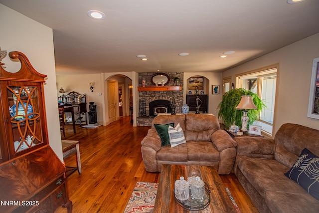 15045 Heathcliff Dr, Reno, NV 89511 - living area with arched walkways, wood finished floors, a fireplace, and recessed lighting