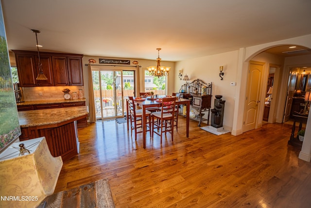 15045 Heathcliff Dr, Reno, NV 89511 - dining area with arched walkways, light wood-style flooring, a chandelier, and recessed lighting