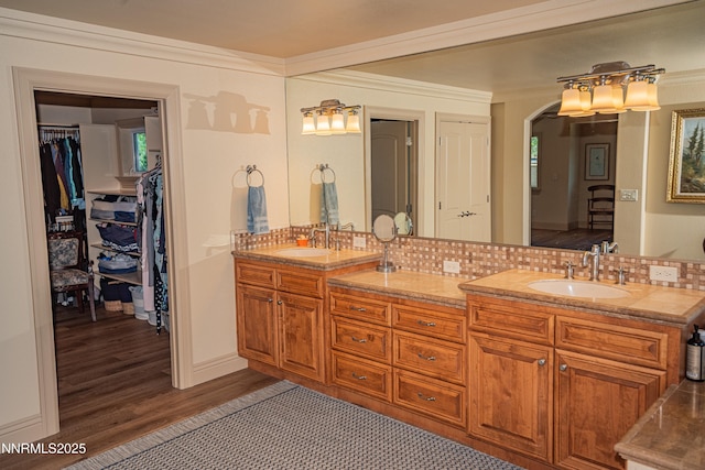 15045 Heathcliff Dr, Reno, NV 89511 - bathroom with double vanity, tasteful backsplash, wood finished floors, a walk in closet, and crown molding