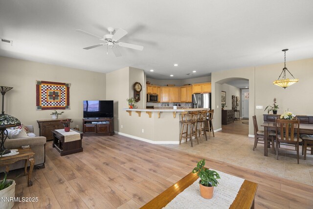 3226 Banestone Rd, Sparks, NV 89436 - living room featuring arched walkways, a ceiling fan, light wood finished floors, and recessed lighting