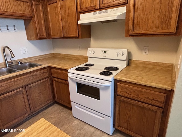 1465 E Peckham Ln Unit 53, Reno, NV 89502 - kitchen featuring white range with electric stovetop, under cabinet range hood, brown cabinets, and light countertops