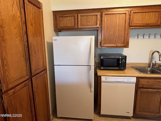 1465 E Peckham Ln Unit 53, Reno, NV 89502 - kitchen with white appliances, brown cabinetry, and light countertops