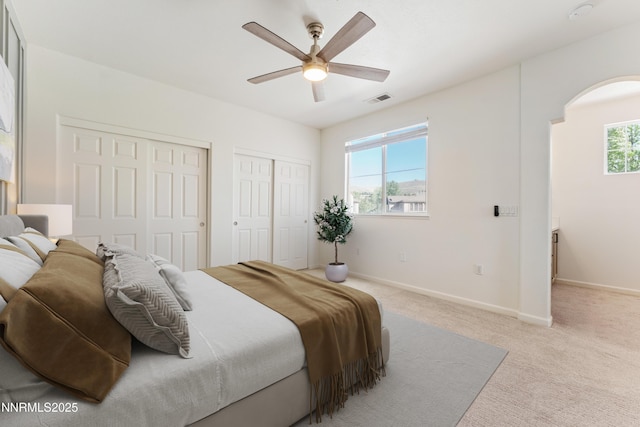 6120 Ingleston Dr Unit 621, Sparks, NV 89436 - bedroom featuring multiple closets, arched walkways, light colored carpet, and ceiling fan