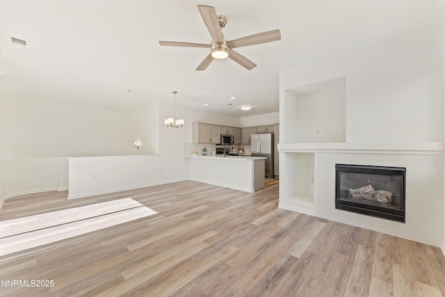 6120 Ingleston Dr Unit 621, Sparks, NV 89436 - unfurnished living room featuring a ceiling fan, light wood-style floors, a chandelier, a tiled fireplace, and recessed lighting