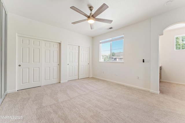 6120 Ingleston Dr Unit 621, Sparks, NV 89436 - unfurnished bedroom featuring multiple closets, arched walkways, light colored carpet, and a ceiling fan