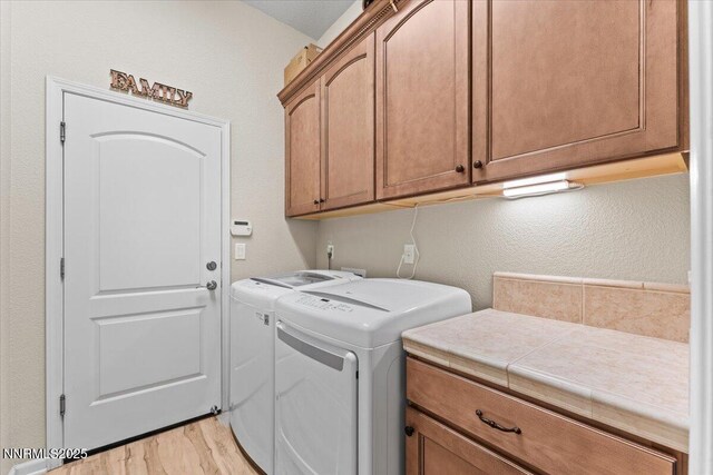 6648 Equation Dr, Sparks, NV 89436 - laundry room featuring cabinet space, washer and clothes dryer, light wood finished floors, and a textured wall
