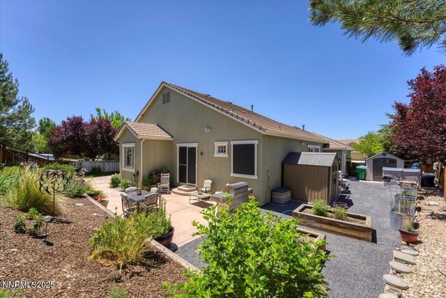 6648 Equation Dr, Sparks, NV 89436 - back of house featuring a storage shed, a vegetable garden, stucco siding, a patio, and a fenced backyard