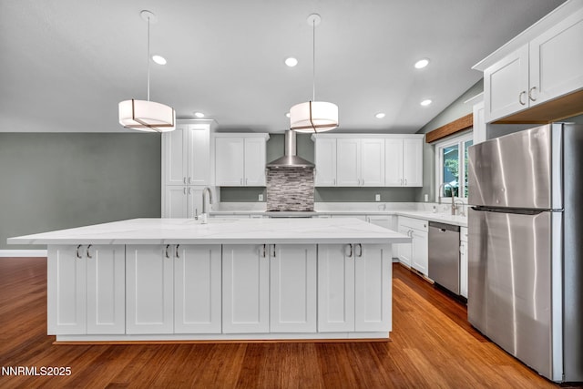 2159 Shadow Brook Ct, Carson City, NV 89703 - kitchen with stainless steel appliances, wall chimney range hood, wood finished floors, white cabinets, and tasteful backsplash