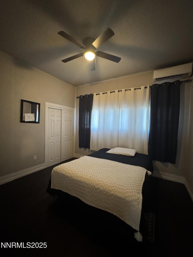 468 S Maine St, Fallon, NV 89406 - carpeted bedroom featuring a wall unit AC, a textured ceiling, a ceiling fan, and a closet