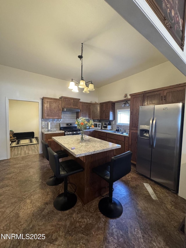 468 S Maine St, Fallon, NV 89406 - kitchen with stainless steel appliances, a center island, pendant lighting, dark brown cabinetry, and decorative backsplash