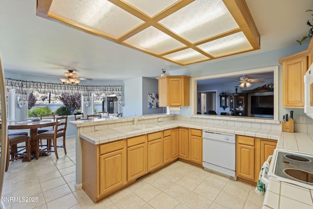 3555 Vista Blvd, Sparks, NV 89436 - kitchen featuring white appliances, ceiling fan, a peninsula, and tile countertops