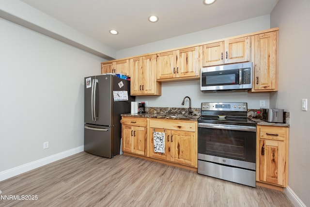 2092 Canterbury Ln, Carson City, NV 89703 - kitchen with stainless steel appliances, light brown cabinetry, light wood-style flooring, recessed lighting, and dark stone countertops