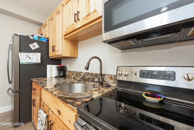 2092 Canterbury Ln, Carson City, NV 89703 - kitchen with appliances with stainless steel finishes, light brown cabinetry, dark stone countertops, and wood finished floors