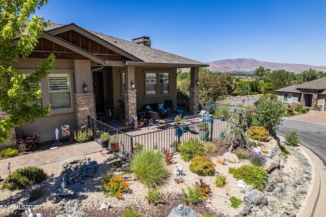 2092 Canterbury Ln, Carson City, NV 89703 - view of front of house featuring a mountain view, stucco siding, a chimney, stone siding, and roof with shingles