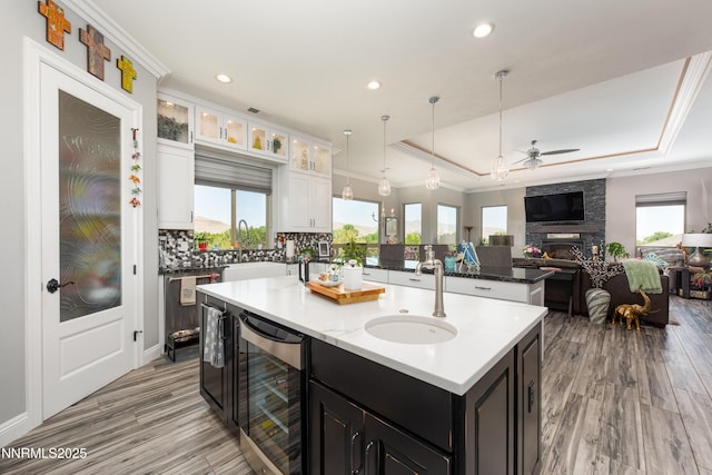 2092 Canterbury Ln, Carson City, NV 89703 - kitchen with wine cooler, a tray ceiling, open floor plan, ceiling fan, and white cabinets